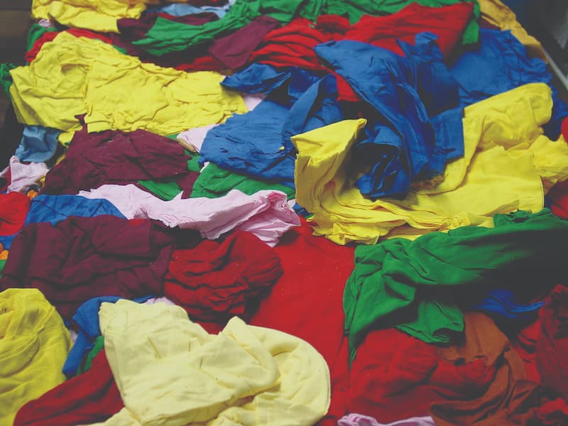 A vibrant assortment of colorful t-shirts stacked together, showcasing a variety of hues and styles