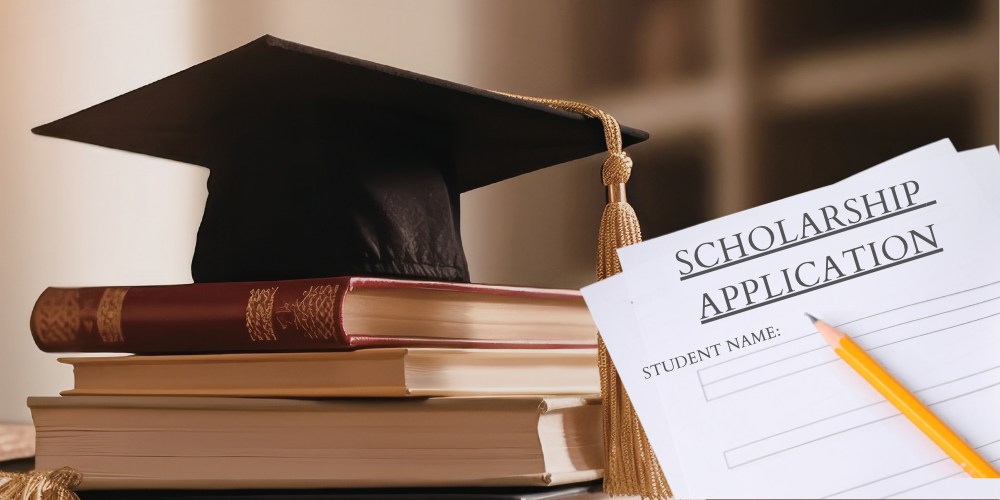 stack of books along with a graduation hat and scholarship application