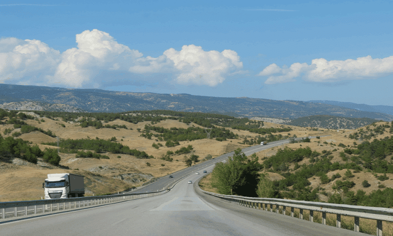 truck on the road with mountains in background