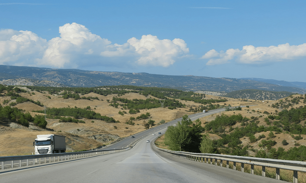 truck on the road with mountains in background